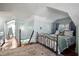 Upper-level bedroom showcases an eye-catching iron bed frame, wooden floors, and a staircase at 634 6Th N St, St Petersburg, FL 33701