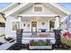 Inviting front porch featuring stone columns, flowers, and a cozy sitting area with decorative pillows at 634 6Th N St, St Petersburg, FL 33701