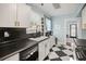 Stylish kitchen featuring white cabinets, black countertops, and black and white checkered tile flooring at 634 6Th N St, St Petersburg, FL 33701