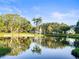 A tranquil park pond reflecting trees and a fountain under a blue sky at 634 6Th N St, St Petersburg, FL 33701