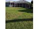 Expansive backyard featuring a large manicured lawn, ideal for recreation and relaxation with a screened patio at 6615 Vanda Ln, Land O Lakes, FL 34637