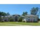 Charming single-story home with lush landscaping and a well-manicured lawn under a clear blue sky at 6615 Vanda Ln, Land O Lakes, FL 34637