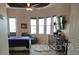 Serene main bedroom with ample natural light, tray ceilings, a ceiling fan, and modern furnishings at 6615 Vanda Ln, Land O Lakes, FL 34637
