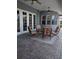 This covered patio features a dining table and chair set, ceiling fans, and a french door entry at 6615 Vanda Ln, Land O Lakes, FL 34637