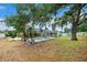 Expansive backyard with a screened pool area, lush trees, and a privacy fence at 6724 Clair Shore Dr, Apollo Beach, FL 33572