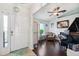Inviting entryway featuring a white front door, tile flooring, and hardwood floors leading to a living area with a piano at 6724 Clair Shore Dr, Apollo Beach, FL 33572