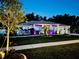 Well-lit single-story home with a lush green lawn, enhancing its nighttime curb appeal at 6724 Clair Shore Dr, Apollo Beach, FL 33572
