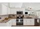Bright kitchen with white cabinetry, stainless appliances, granite countertops, open to the living area, and stylish backsplash at 6724 Clair Shore Dr, Apollo Beach, FL 33572