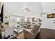 Open living room features a ceiling fan, neutral furniture, fireplace, and access to screened patio at 6724 Clair Shore Dr, Apollo Beach, FL 33572