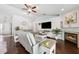 Comfortable living room with a fireplace, hardwood flooring, large television, and stylish coastal decor at 6724 Clair Shore Dr, Apollo Beach, FL 33572
