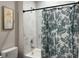 Bathroom boasts a shower with a floral curtain and modern marble tile surround at 6977 Hawksbury St, Englewood, FL 34224
