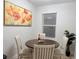 Cozy dining area featuring a round table with seating for four and a large floral painting at 6977 Hawksbury St, Englewood, FL 34224