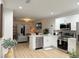Modern kitchen open to the living room with stainless steel appliances and a kitchen island at 6977 Hawksbury St, Englewood, FL 34224