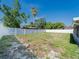 Large backyard with a white fence and some trees, offering privacy and space for outdoor activities at 7131 Vista Way, Port Richey, FL 34668