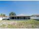 Full view of the back of the home, with a white fence, and a covered patio and plenty of green space at 7131 Vista Way, Port Richey, FL 34668