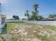 Expansive backyard featuring a white fence, mature trees, and ample space for outdoor activities at 7131 Vista Way, Port Richey, FL 34668