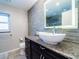 Bathroom featuring a modern vanity with granite counters, vessel sink, and tiled backsplash at 7131 Vista Way, Port Richey, FL 34668