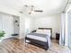 Bright main bedroom has a ceiling fan, hardwood floors, and sliding glass doors to the back yard at 7131 Vista Way, Port Richey, FL 34668