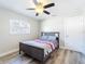Bedroom featuring a ceiling fan, large window, neutral walls, and wood-look flooring at 7131 Vista Way, Port Richey, FL 34668