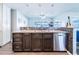 Open kitchen featuring sleek dark wood cabinets, silver hardware, and a stainless steel dishwasher at 7131 Vista Way, Port Richey, FL 34668