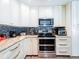 Modern kitchen boasts white cabinets, granite countertops, and stainless steel appliances at 7131 Vista Way, Port Richey, FL 34668