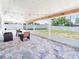 Spacious covered lanai featuring brick floors, outdoor string lights, and lots of light at 7131 Vista Way, Port Richey, FL 34668