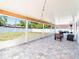 Spacious covered lanai featuring brick floors, outdoor string lights, and lots of light at 7131 Vista Way, Port Richey, FL 34668