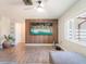 Modern living room featuring wood accent wall with mounted TV and gray wood floors at 7131 Vista Way, Port Richey, FL 34668