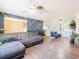 Open concept living room boasts modern decor, including a gray sofa and stylish accent wall at 7131 Vista Way, Port Richey, FL 34668