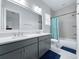 Bathroom featuring double sink vanity, large mirror, tile flooring, and bath tub with shower at 718 W Kentucky Ave, Tampa, FL 33603