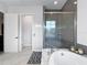 Bathroom features a soaking tub, a large shower with gray subway tile, and tiled floors and bathmat at 718 W Kentucky Ave, Tampa, FL 33603