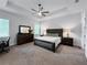 Bedroom features tray ceiling, ceiling fan, plush carpeting, and coordinated bedroom set at 718 W Kentucky Ave, Tampa, FL 33603