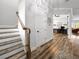 Bright hallway with wooden floors, a staircase, and a view into a home office and living room at 718 W Kentucky Ave, Tampa, FL 33603