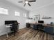 Bright office space with two desks and a ceiling fan in a room with wood-look floors and blue cabinets at 718 W Kentucky Ave, Tampa, FL 33603