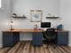 Spacious office featuring a custom desk with blue cabinets and floating shelves with wood-look floors and natural light at 718 W Kentucky Ave, Tampa, FL 33603