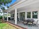 Covered outdoor patio with brick flooring, dining table, seating area, and grill at 718 W Kentucky Ave, Tampa, FL 33603