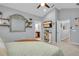 Bright bedroom with ceiling fan, TV, and ensuite bath and adjacent hall visible at 7238 Milestone Dr, Apollo Beach, FL 33572