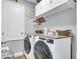 Functional laundry room featuring a washer and dryer, overhead storage, and clean finishes at 7238 Milestone Dr, Apollo Beach, FL 33572