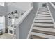 View of white and grey carpeted stairs in the home with an electric fireplace and shelving underneath at 7238 Milestone Dr, Apollo Beach, FL 33572