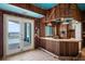 Vintage bar area with a tile counter, wood finishes, and view of the pool and ocean at 812 Point Seaside Dr, Crystal Beach, FL 34681
