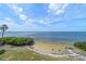 Serene beach landscape with lush greenery, palm tree and crystal clear water and sandy shoreline at 812 Point Seaside Dr, Crystal Beach, FL 34681