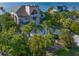 Beautiful exterior view highlighting lush tropical landscaping, a circular driveway, and a waterfront location at 812 Point Seaside Dr, Crystal Beach, FL 34681