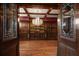 View through French doors of an opulent game room with a chandelier, hardwood floors, and custom woodwork at 812 Point Seaside Dr, Crystal Beach, FL 34681