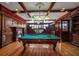 Elegant game room featuring a pool table, fireplace, custom wood paneling, and coffered ceiling at 812 Point Seaside Dr, Crystal Beach, FL 34681