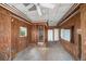 Spacious living room featuring wood paneling, neutral walls, and a ceiling fan for comfortable living at 812 Point Seaside Dr, Crystal Beach, FL 34681