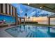 Outdoor pool with a mural, palm trees, and scenic waterfront views at sunset at 812 Point Seaside Dr, Crystal Beach, FL 34681