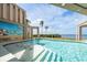 Inviting swimming pool with murals, palm trees, and serene ocean views for relaxation and enjoyment at 812 Point Seaside Dr, Crystal Beach, FL 34681