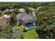 Aerial view of the property showcasing a large backyard, screened-in pool, and mature trees for added privacy at 9223 Brindlewood Dr, Odessa, FL 33556
