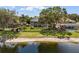 Backyard featuring lush greenery, a screened-in patio, mature trees, access to the lake and a fence at 9223 Brindlewood Dr, Odessa, FL 33556