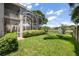Large backyard featuring lush lawn, manicured landscaping, screened in patio, mature trees, and access to the lake at 9223 Brindlewood Dr, Odessa, FL 33556